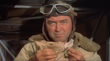 Movie still from “The Spirit of St. Louis” (1957), directed by Billy Wilder – A man wearing a helmet and goggles while holding something; Close Up shot, Low angle