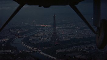 Movie still from “The Spirit of St. Louis” (1957), directed by Billy Wilder – The eiffel tower is lit up at night in paris; Extreme Wide shot, High angle
