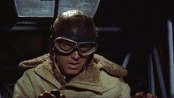 Movie still from “The Spirit of St. Louis” (1957), directed by Billy Wilder – A man wearing a helmet and goggles while sitting in a car; Close Up shot, Low angle