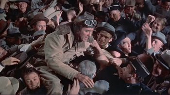 Movie still from “The Spirit of St. Louis” (1957), directed by Billy Wilder – A man in a crowd of people wearing hats and goggles; Wide shot, High angle