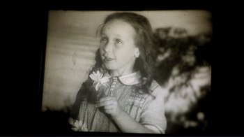 Movie still from “The Spirit of the Beehive” (1973), directed by Víctor Erice – An old photo of a young girl holding a flower; Close Up shot, High angle