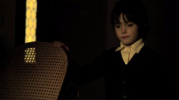 Movie still from “The Spirit of the Beehive” (1973), directed by Víctor Erice – A young boy in a black shirt and a white shirt; Medium shot, High angle