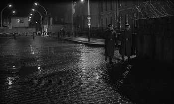 Movie still from “The Spy Who Came in from the Cold” (1965), directed by Martin Ritt – A couple of men standing next to each other on a street; Wide shot, High angle