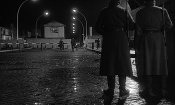 Movie still from “The Spy Who Came in from the Cold” (1965), directed by Martin Ritt – A group of people walking down a street at night; Wide shot, Low angle