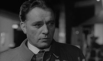 Movie still from “The Spy Who Came in from the Cold” (1965), directed by Martin Ritt – Black and white photograph of a man wearing a suit and tie; Close Up shot, Low angle