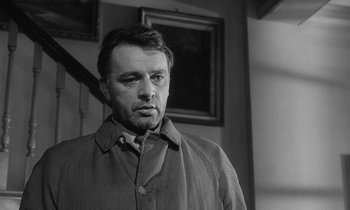 Movie still from “The Spy Who Came in from the Cold” (1965), directed by Martin Ritt – Black and white photograph of a man in a jacket; Close Up shot, Low angle