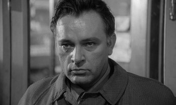 Movie still from “The Spy Who Came in from the Cold” (1965), directed by Martin Ritt – Black and white photograph of a man looking at the camera; Close Up shot, Low angle