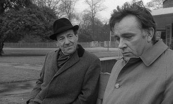 Movie still from “The Spy Who Came in from the Cold” (1965), directed by Martin Ritt – Two men sitting on a bench in a park; Medium shot, Over the shoulder angle