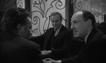 Movie still from “The Spy Who Came in from the Cold” (1965), directed by Martin Ritt – A group of men sitting around a table; Medium shot, Over the shoulder angle