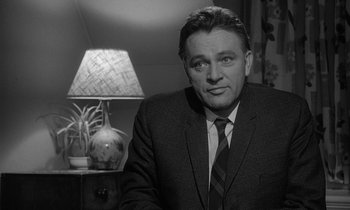 Movie still from “The Spy Who Came in from the Cold” (1965), directed by Martin Ritt – Black and white photograph of a man in a suit and tie; Close Up shot, Low angle