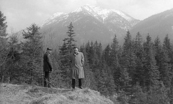 Movie still from “The Spy Who Came in from the Cold” (1965), directed by Martin Ritt – Two men standing on top of a hill in front of a snowy mountain; Extreme Wide shot, High angle