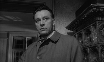 Movie still from “The Spy Who Came in from the Cold” (1965), directed by Martin Ritt – Black and white photograph of a man wearing a jacket; Close Up shot, Low angle