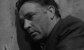 Movie still from “The Spy Who Came in from the Cold” (1965), directed by Martin Ritt – Black and white photograph of a man in a suit and tie; Close Up shot, High angle