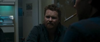 Movie still from “The Square” (2008), directed by Nash Edgerton – A man sitting in a room looking at the camera; Close Up shot, Over the shoulder angle