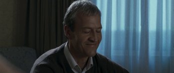 Movie still from “The Square” (2008), directed by Nash Edgerton – A person sitting in front of a window; Close Up shot, Low angle