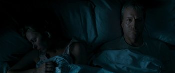 Movie still from “The Square” (2008), directed by Nash Edgerton – A person sleeping in a bed under a blue blanket; Medium shot, High angle