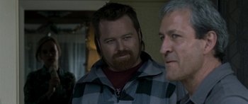 Movie still from “The Square” (2008), directed by Nash Edgerton – A man with a beard and a plaid jacket; Close Up shot, Over the shoulder angle