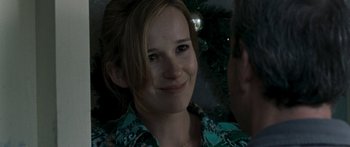 Movie still from “The Square” (2008), directed by Nash Edgerton – A young woman smiles at the camera in front of a christmas tree; Close Up shot, Over the shoulder angle