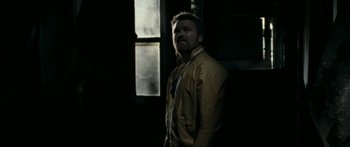 Movie still from “The Square” (2008), directed by Nash Edgerton – A man standing in the dark in front of a window; Medium shot, Low angle