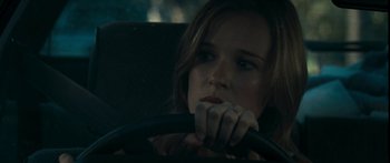 Movie still from “The Square” (2008), directed by Nash Edgerton – A woman sitting in the driver's seat of a car holding a steering wheel; Close Up shot, Over the shoulder angle
