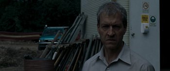 Movie still from “The Square” (2008), directed by Nash Edgerton – A person standing in front of a bunch of baseball bats; Close Up shot, Over the shoulder angle