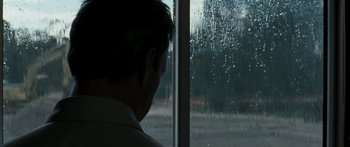 Movie still from “The Square” (2008), directed by Nash Edgerton – A man standing in front of a window looking outside; Close Up shot, Over the shoulder angle