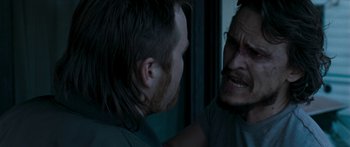 Movie still from “The Square” (2008), directed by Nash Edgerton – A man with long red hair is looking at another man with long hair; Close Up shot, Over the shoulder angle