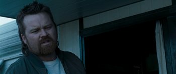 Movie still from “The Square” (2008), directed by Nash Edgerton – A man standing in front of a garage door at night; Close Up shot, Over the shoulder angle