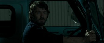 Movie still from “The Square” (2008), directed by Nash Edgerton – A man sitting in the driver's seat of a car; Close Up shot, Over the shoulder angle