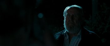 Movie still from “The Square” (2008), directed by Nash Edgerton – An old man with a beard is looking into the distance; Close Up shot, Over the shoulder angle
