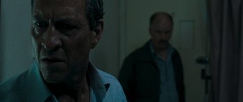 Movie still from “The Square” (2008), directed by Nash Edgerton – Two men standing next to each other in front of a wall; Close Up shot, Over the shoulder angle