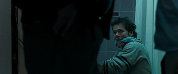 Movie still from “The Square” (2008), directed by Nash Edgerton – A man with his mouth taped shut in front of a mirror; Close Up shot, Over the shoulder angle