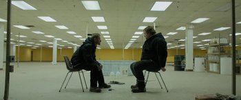 Two men sitting on chairs in a room