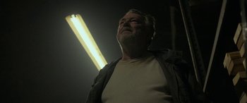 An older man standing in a dimly lit room