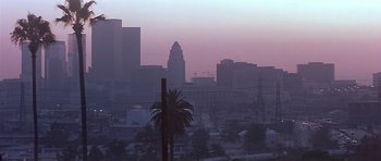 Movie still from “The Star Chamber” (1983), directed by Peter Hyams – A palm tree in front of a city skyline at dusk; Extreme Wide shot, Low angle