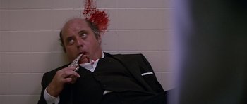 Movie still from “The Star Chamber” (1983), directed by Peter Hyams – A man in a suit and tie eating a piece of food; Close Up shot, Low angle