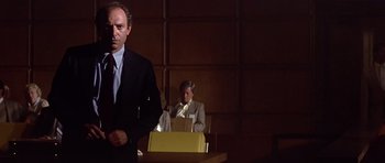 Movie still from “The Star Chamber” (1983), directed by Peter Hyams – A man standing in front of another man in a suit; Medium shot, Low angle