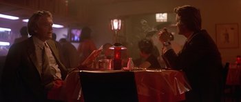 Movie still from “The Star Chamber” (1983), directed by Peter Hyams – People are sitting at a table in a restaurant; Medium shot, Low angle