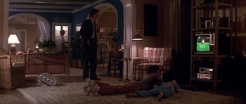 Movie still from “The Star Chamber” (1983), directed by Peter Hyams – A group of people laying on the floor in a living room; Wide shot, Over the shoulder angle