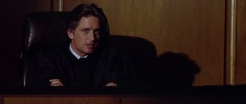 Movie still from “The Star Chamber” (1983), directed by Peter Hyams – A man sitting in front of a judge's chair; Close Up shot, Low angle
