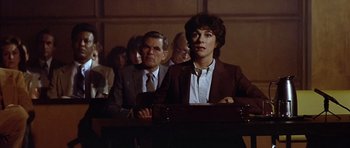 Movie still from “The Star Chamber” (1983), directed by Peter Hyams – A man and a woman sitting in front of a microphone; Medium shot, High angle