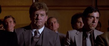 Movie still from “The Star Chamber” (1983), directed by Peter Hyams – A man in a suit standing next to another man in a suit; Close Up shot, Low angle