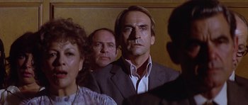 Movie still from “The Star Chamber” (1983), directed by Peter Hyams – A man in a suit and tie standing in front of other people; Close Up shot, Over the shoulder angle