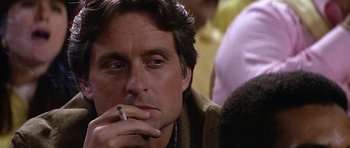 Movie still from “The Star Chamber” (1983), directed by Peter Hyams – A person smoking a cigarette; Close Up shot, Over the shoulder angle