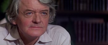 Movie still from “The Star Chamber” (1983), directed by Peter Hyams – An older man wearing a white shirt with a book shelf in the background; Close Up shot, Over the shoulder angle