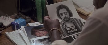 Movie still from “The Star Chamber” (1983), directed by Peter Hyams – A person holding a picture of a man with long hair; Extreme Close Up shot, High angle