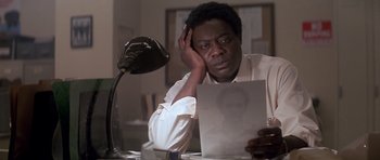 Movie still from “The Star Chamber” (1983), directed by Peter Hyams – A man sitting at a desk looking at a sheet of paper; Close Up shot, High angle