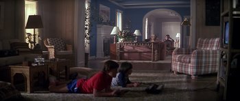 Movie still from “The Star Chamber” (1983), directed by Peter Hyams – Two children are laying on the floor in a living room; Wide shot, Low angle
