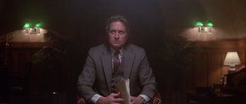 Movie still from “The Star Chamber” (1983), directed by Peter Hyams – A man in a suit and tie holding papers; Medium shot, Low angle