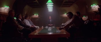 Movie still from “The Star Chamber” (1983), directed by Peter Hyams – A group of people sitting around a table in a dark room; Wide shot, Low angle